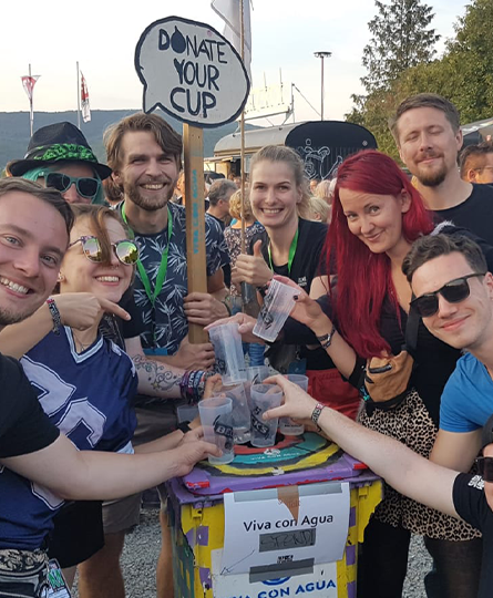 Mehrere Teammitglieder spenden Becher für Viva con Agua