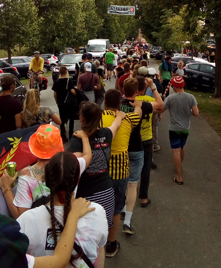 In einer Polonaise ziehen viele Festival-Besucher:innen und Hunter:innen Richtung Festivalgelände
