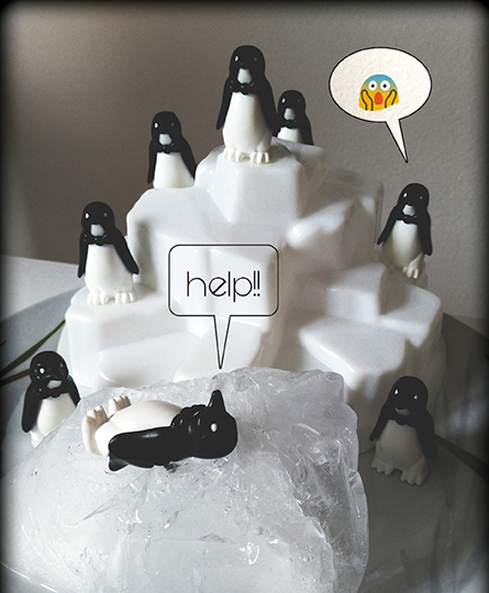 Ein Playmobil-Eisberg mit Pinguinfiguren. Im Vordergrund echtes Eis, auf dem eine Pinguinfigur liegt und um Hilfe ruft, um das Schmelzen anzudeuten