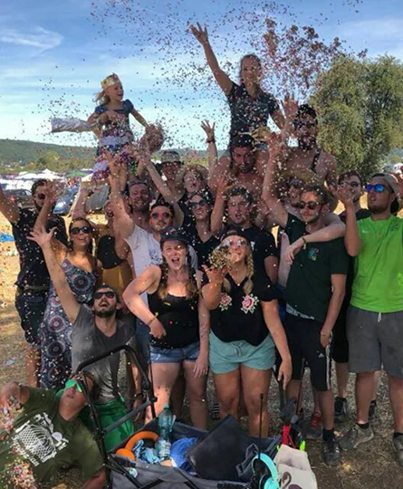 Gruppe von Menschen jubelt zusammen und wirft Konfetti als Lösung zur Scavenger Hunt Aufgabe "Euer Team als Sieger der OPEN FLAIR Hunt