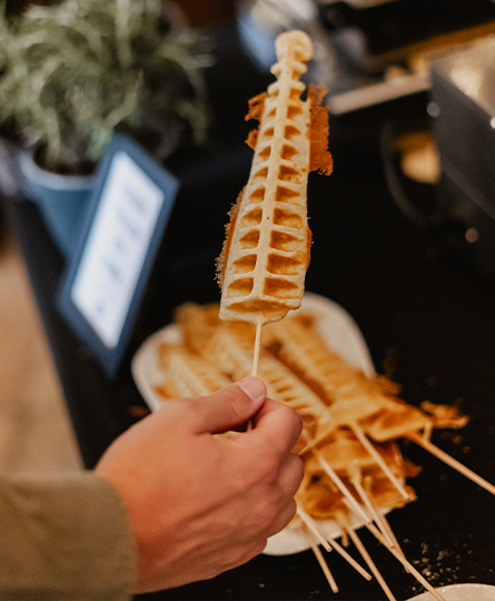 Waffel am Stiel als Nervennahrung Nahaufnahme von einer Hand, die eine Waffel am Stiel vom Büffet nimmt