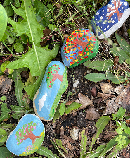 Bemalte Steine auf dem Boden, jeder Stein steht für eine Jahreszeit und ist entsprechend bemalt