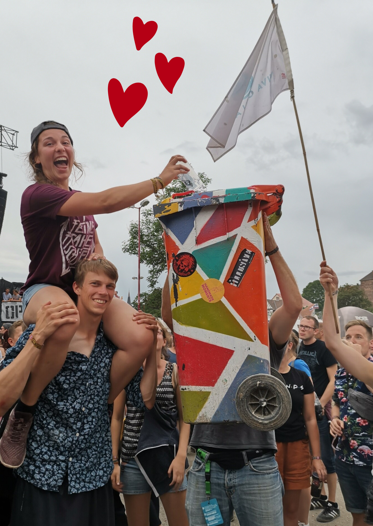 Team spendet Becher für Viva con Agua, sie sitzt auf den Schultern  eines jungen Mannes, die bunte Sammeltonne wird auch hochgehalten