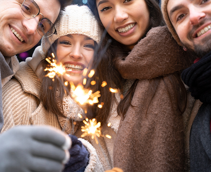 Gruppe von Menschen mit Wunderkerze, winterlich gekleidet